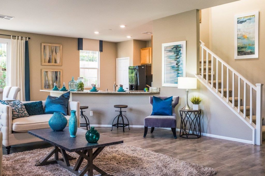 A cozy living room with blue and white decor, featuring a comfortable sofa, elegant curtains, and a stylish coffee table.