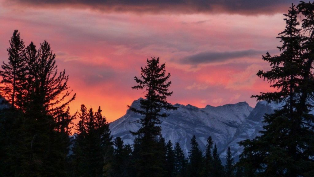 Orange sky over snow-covered mountains.