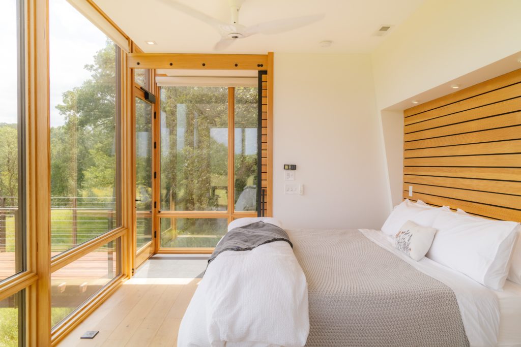 A bedroom with a large window offering a view of the outdoors.