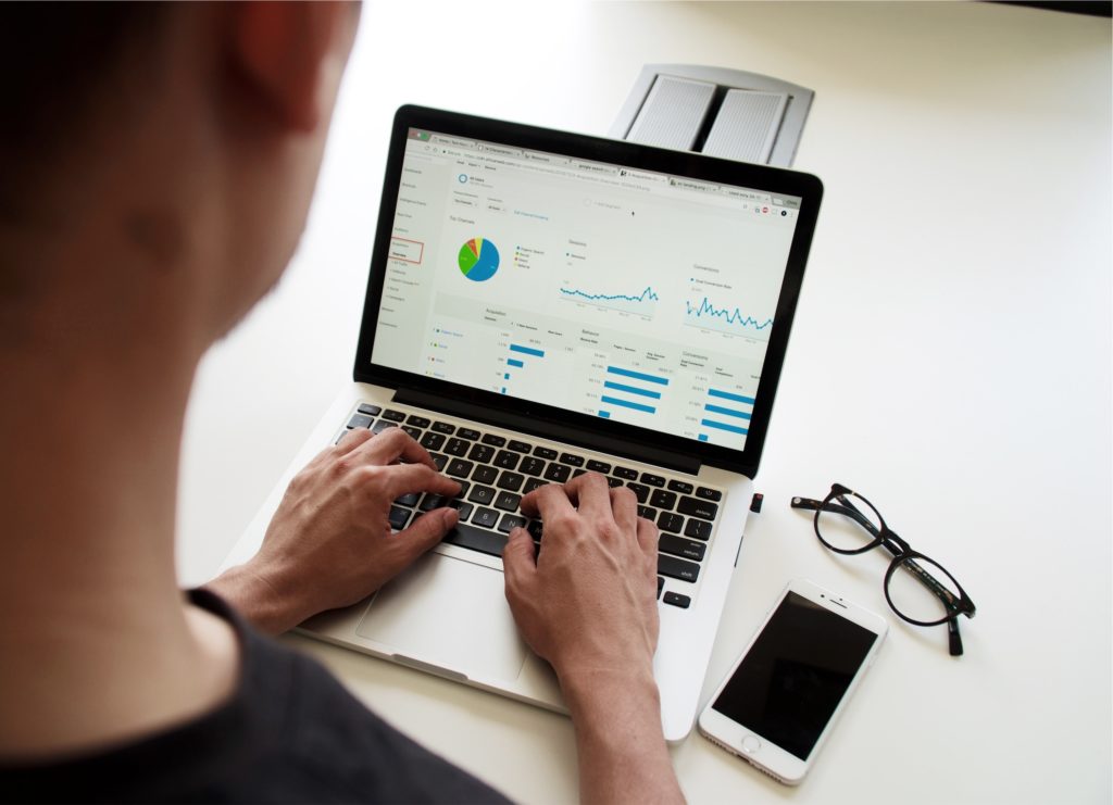 A person analyzing data on a computer screen with Google Analytics interface.